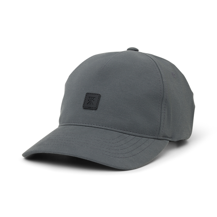 Charcoal gray Layover Strapback Hat with small square logo patch on front, displayed on white background
