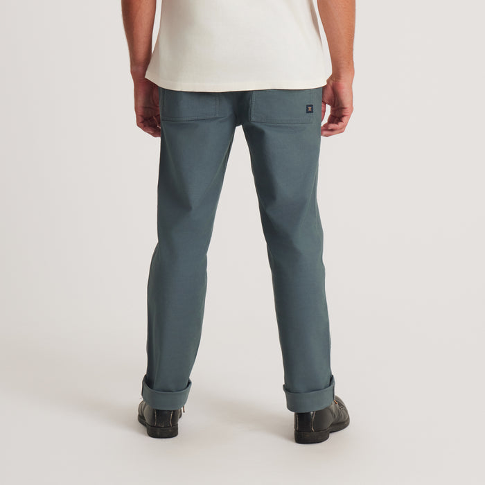 The back view highlights the detailing of the Roark utility pants, designed for durability and functionality, perfect for adventurous outings.