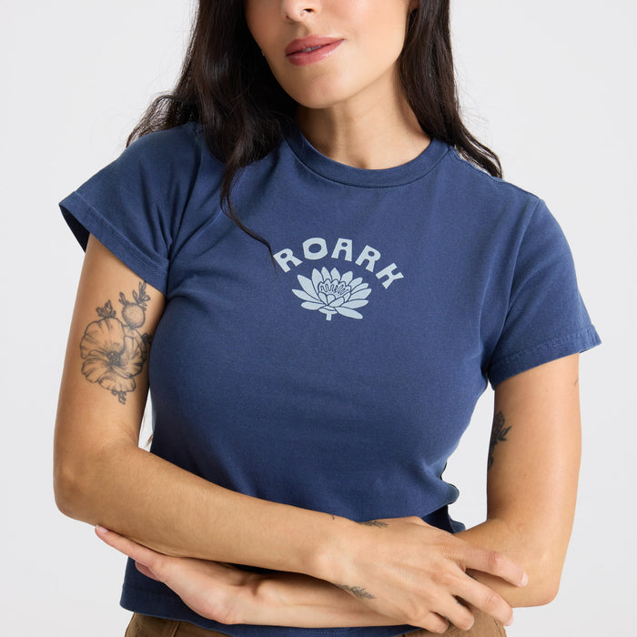 Happy model in a casual Muse Tee with nep texture and denim jeans at an outdoor photoshoot, embodying Roark's adventure and travel spirit.