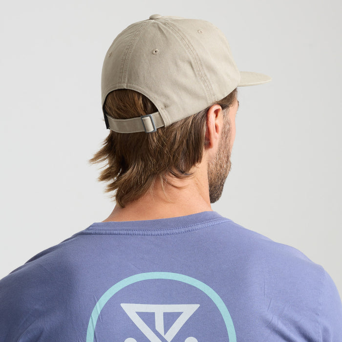 Man wearing a baseball cap featuring adventure-inspired design, highlighting Roark's commitment to outdoor and travel gear.