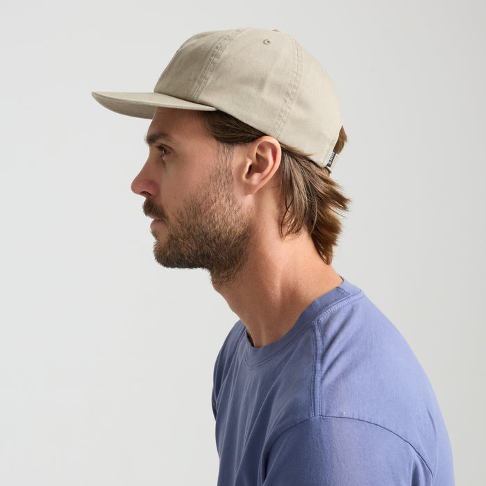 Adventurous man sporting a Roark-style wide-brimmed sun hat, framed by an outdoor backdrop, embodying the spirit of exploration.