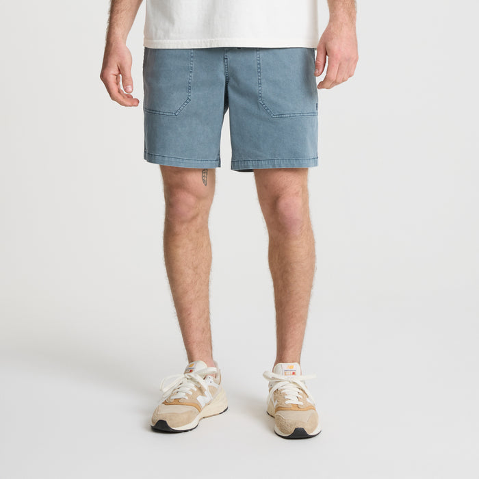 on-model Bermuda shorts, boardshorts, and trunks laid out on sandy beach, capturing the adventurous spirit of travel and outdoor lifestyle.