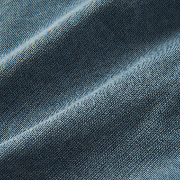 Close-up of textured woven fabric in shades of blue representing durable outdoor apparel, ideal for adventure and travel.