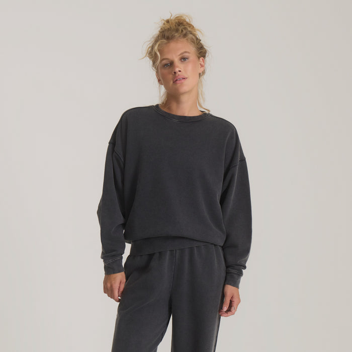 Made To Fade Fleece Hoodie in vintage black worn by model, cropped silhouette with ribbed cuffs and hem visible
