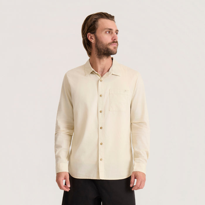 Cream long sleeve button up shirt with chest pocket worn by man against neutral background, front view