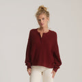 Made To Fade Sweater in cherrywood red ribbed knit with henley neckline, worn on model with cream pants