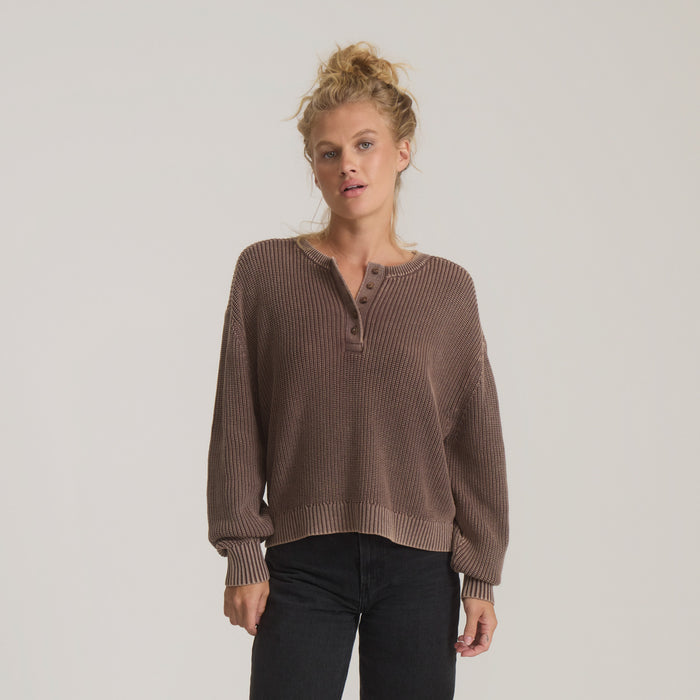 Taupe ribbed henley sweater with long sleeves and button placket worn by model with black jeans