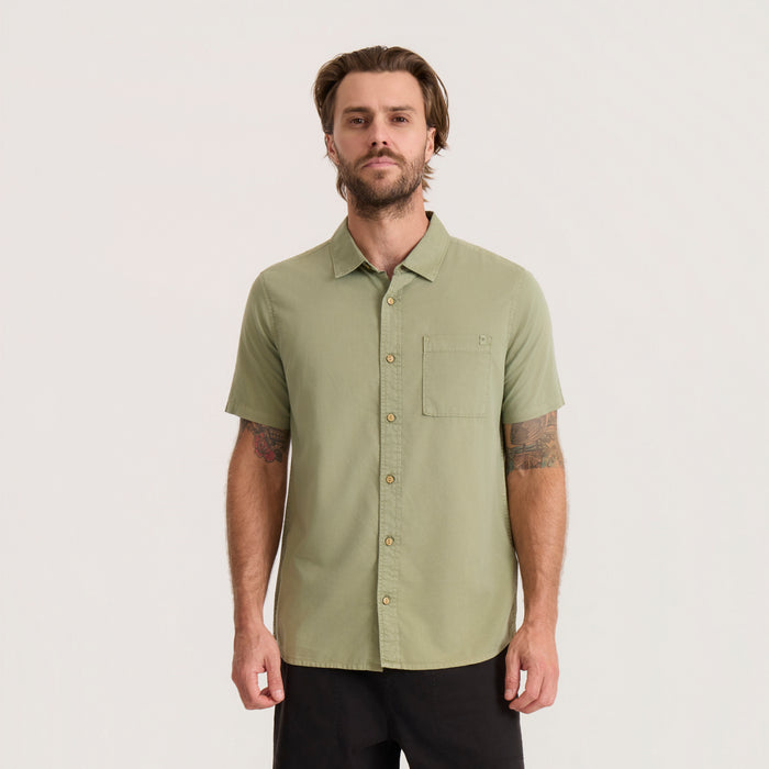 Washed dusty sage short sleeve button up shirt with chest pocket worn by man on neutral background