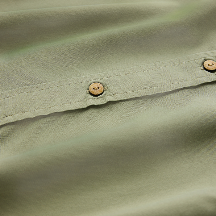 Made To Fade short sleeve button up shirt in washed dusty sage with wooden buttons, close-up detail shot