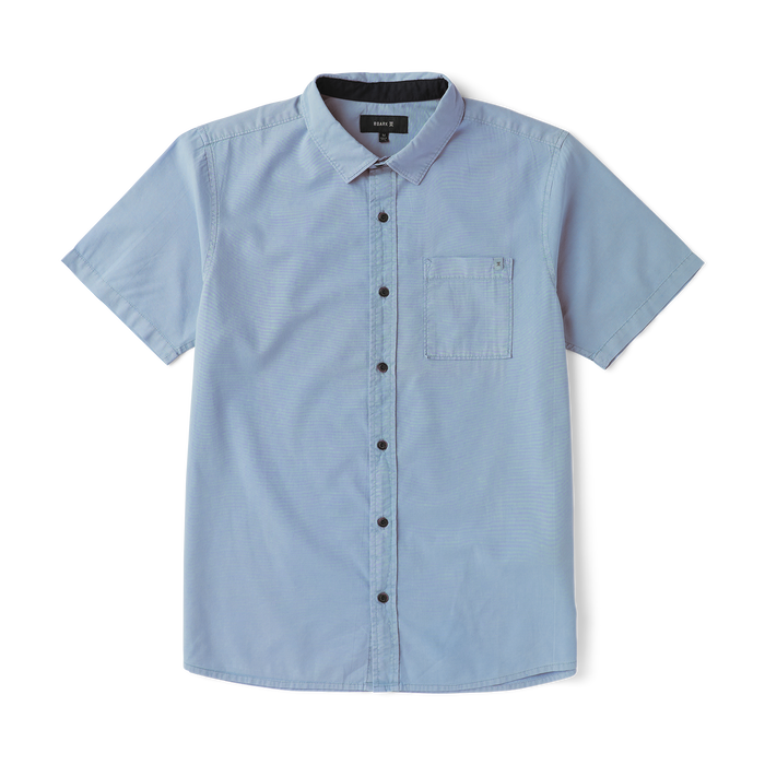 Close-up of a rugged denim dress shirt featuring durable buttons and a crisp collar, ideal for adventure and travel.