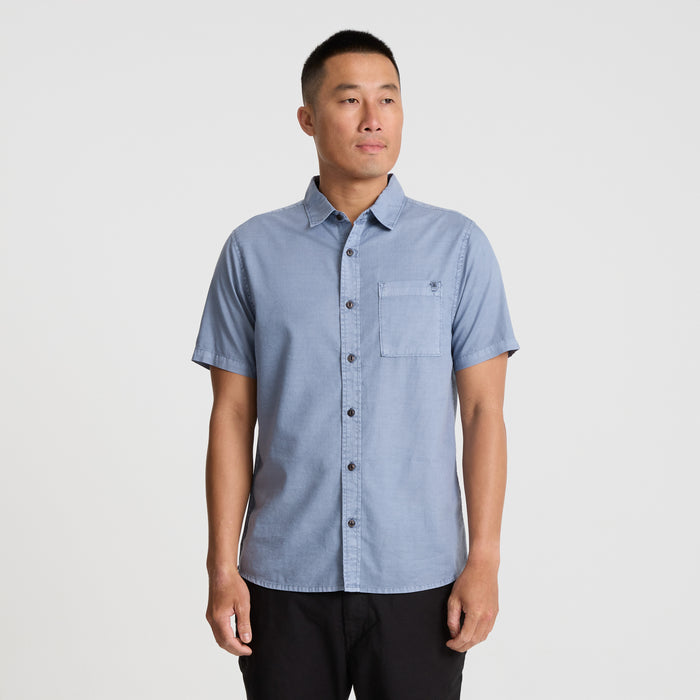 Close-up of a durable Roark men's dress shirt showcasing detailed sleeve, collar, button, and pocket design, ideal for adventure and travel.