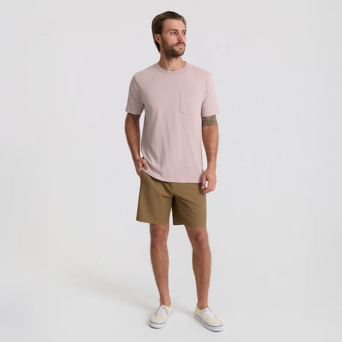 Adventurous person standing in a scenic outdoor setting wearing versatile Bermuda shorts, ideal for travel and exploration.
