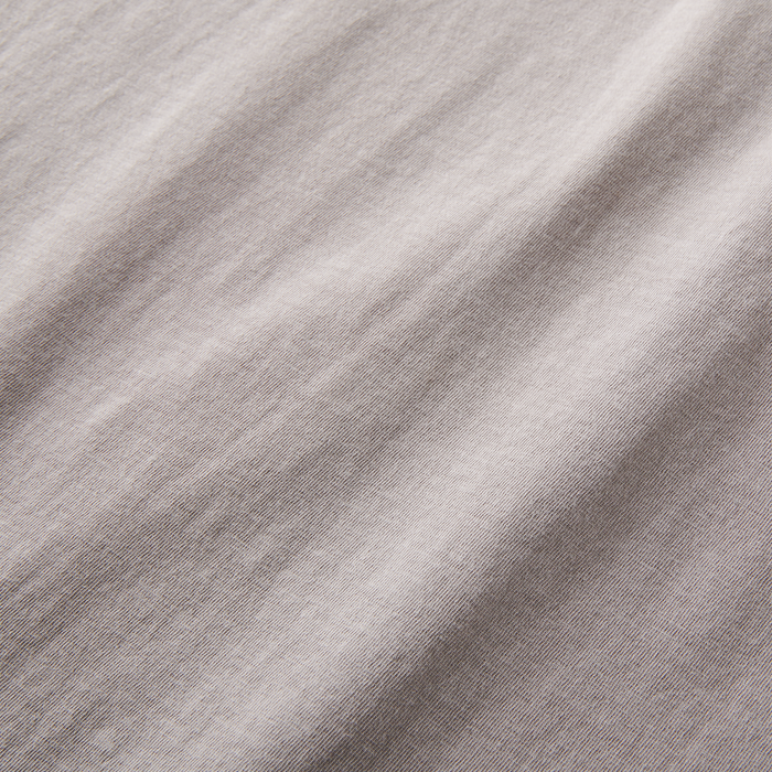 Detailed view of soft, textured cotton fabric in a light grey t-shirt. Ideal for a stylish yet comfortable outfit.