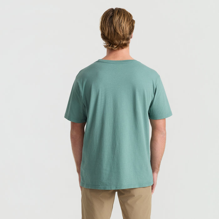 Active traveler wearing a Roark white active shirt with visible neck and sleeves, ready for an outdoor vacation adventure.