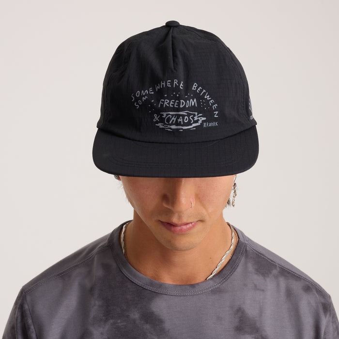 Man wearing a versatile black Roark cap and active shirt, styled for adventure and outdoor activities.