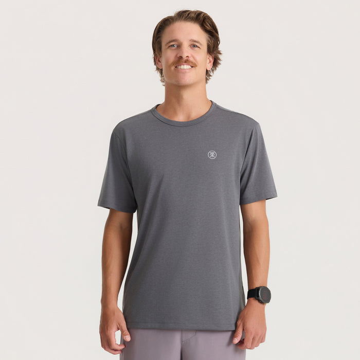 Charcoal Mathis Active Core Short Sleeve Tee worn by man standing against neutral background with small chest logo