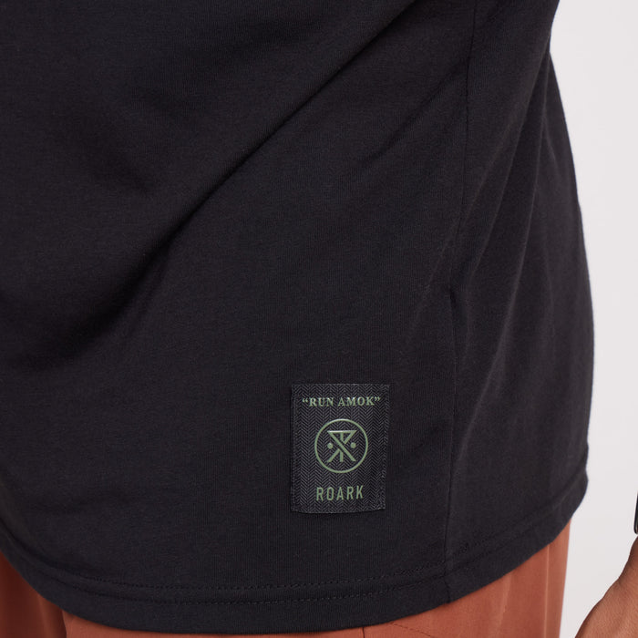 Close-up of the functional details on a Roark grey active shirt featuring a sleeve pocket, emphasizing durability and comfort for adventure travel.