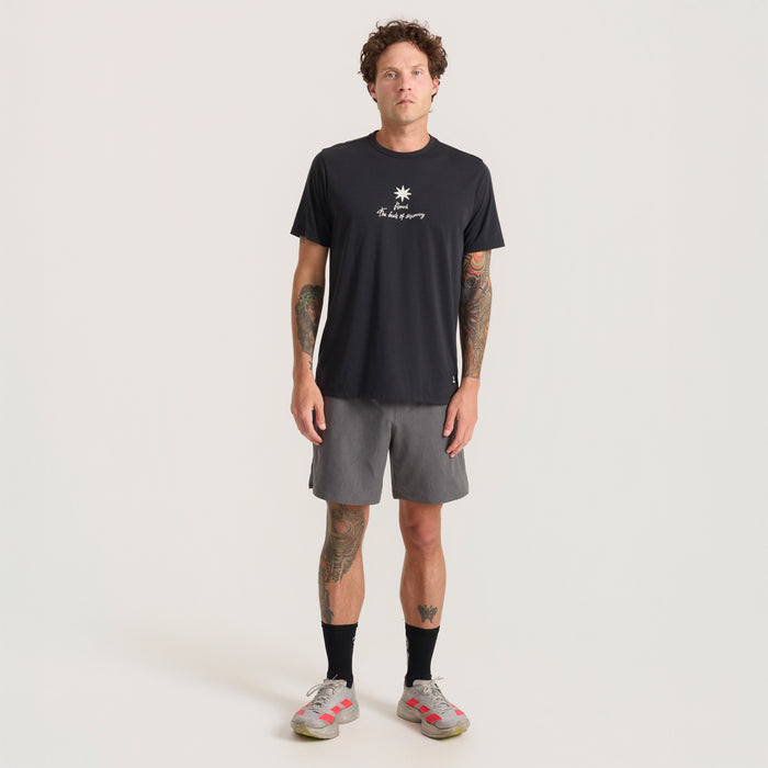 Person standing in sporty attire, featuring an active shirt and shorts, ready for outdoor adventure