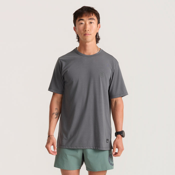 Man outfitted in Roark activewear featuring a long-sleeve shirt with pockets and Bermuda shorts, ready for adventure.
