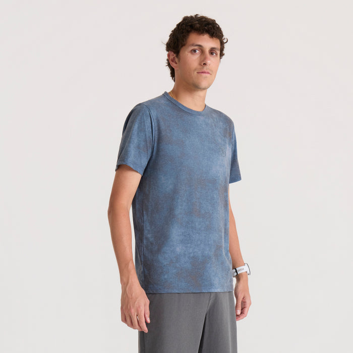 Mathis Active Allover Short Sleeve Tee in dark slate blue worn by male model with gray pants against neutral background