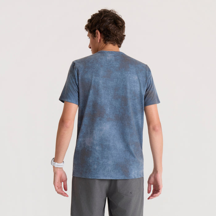Man wearing blue heathered short sleeve t-shirt and gray shorts, shown from back view against neutral background