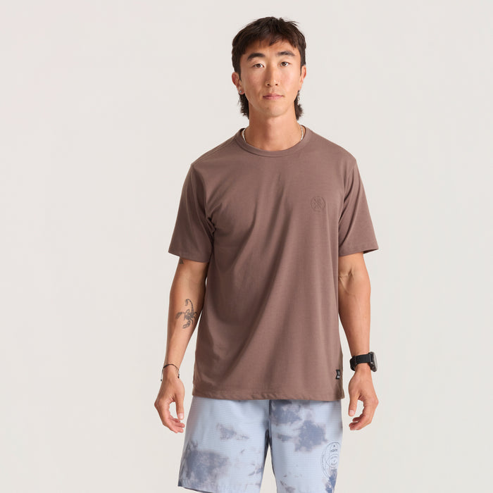 Active person decked out in Roark gear including an active shirt and Bermuda shorts, equipped with pockets for outdoor exploration.