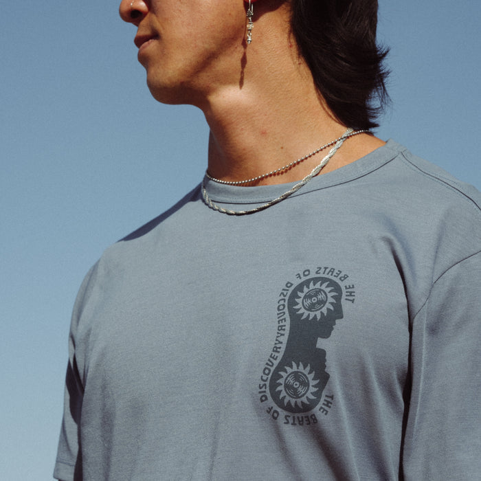 Man wearing Roark Mathis Active Short Sleeve Tee while hiking in a forest, showcasing the shirt's comfortable fit and durability in an outdoor adventure setting.