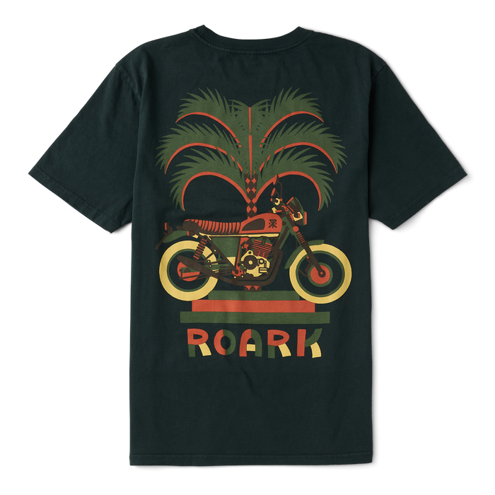 Adventurous rider wearing Roark active shirt while riding a motorcycle through rugged terrain.