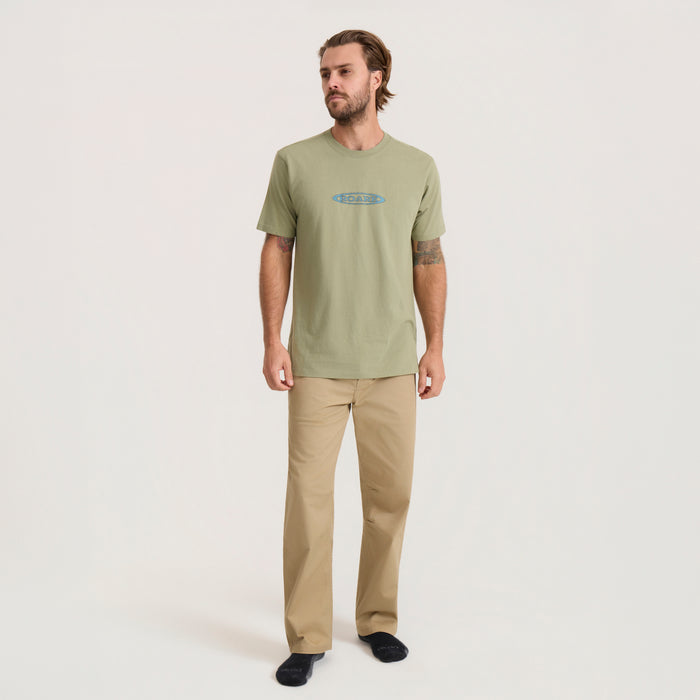 Men's Moto Premium Tee in dusty sage with blue logo, styled with tan pants on model