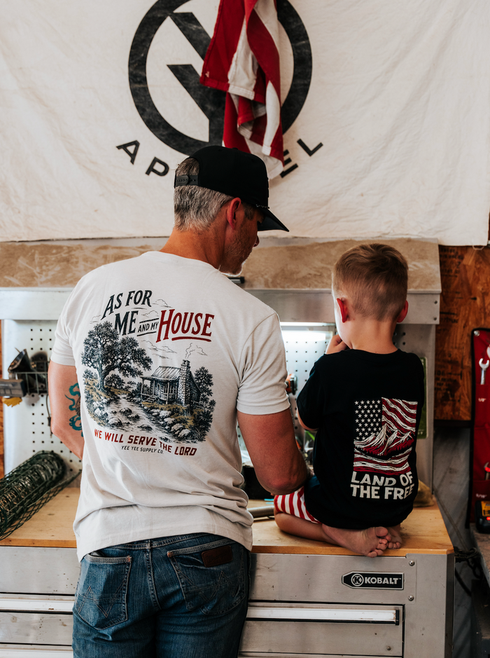 Man and child in a workshop with a 'G' logo on a banner