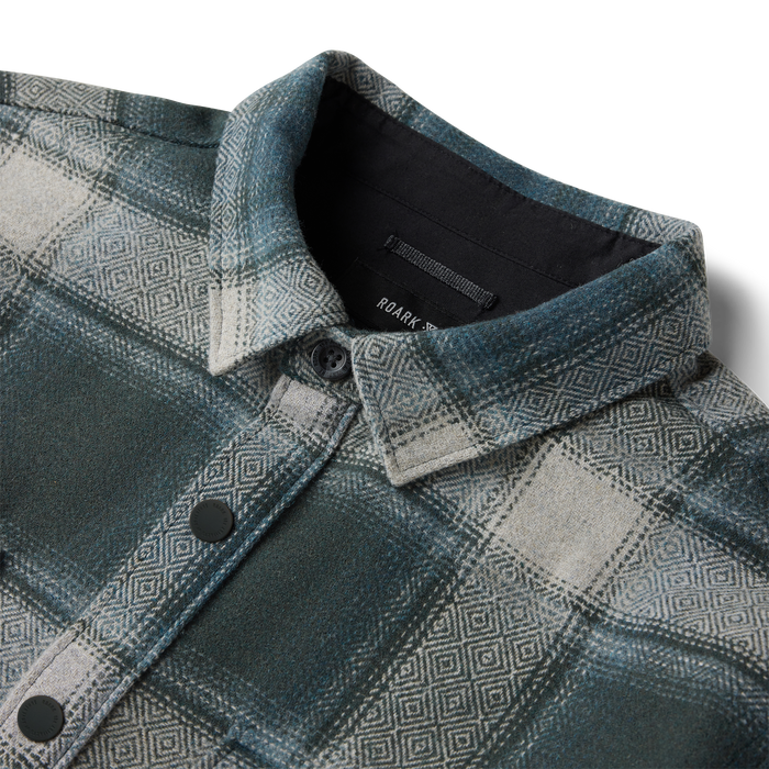 Nordsman 2.0 long sleeve flannel in dark slate with geometric pattern, showing collar detail and black buttons on flat lay