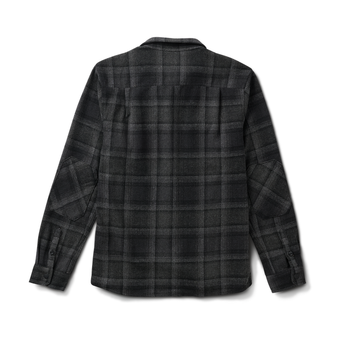 Close-up view of a plaid button detailing on a Roark adventure shirt, perfect for travel and outdoor activities.