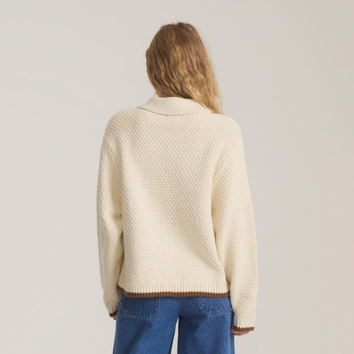 Cream Open Roads Cardigan with textured knit pattern and brown trim, worn on model with jeans, back view