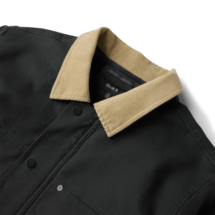 Black waxed canvas jacket with tan corduroy collar, featuring button front closure and visible brand label detail
