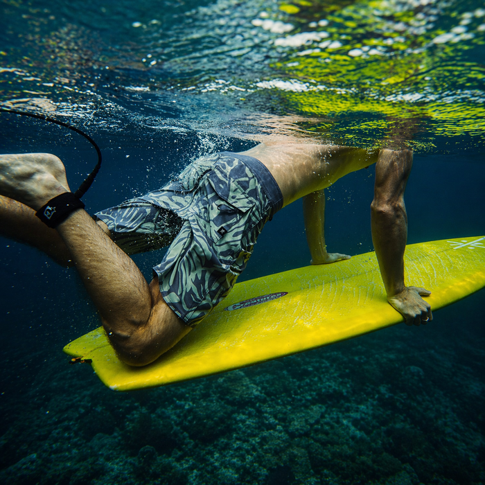 Dynamic underwater surfing action captured in a square frame, showcasing a surfer slicing through ocean waves with precision, highlighting the thrill of water sports and adventure.