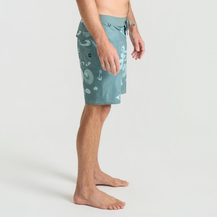 Man in versatile boardshorts ready for outdoor adventure by the sea, embodying the spirit of travel and exploration.