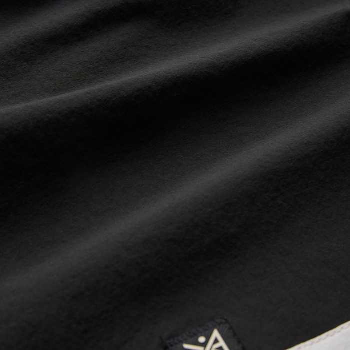 Passage Panel Boardshorts in black with white panel detail, close-up of fabric texture and drape on flat lay