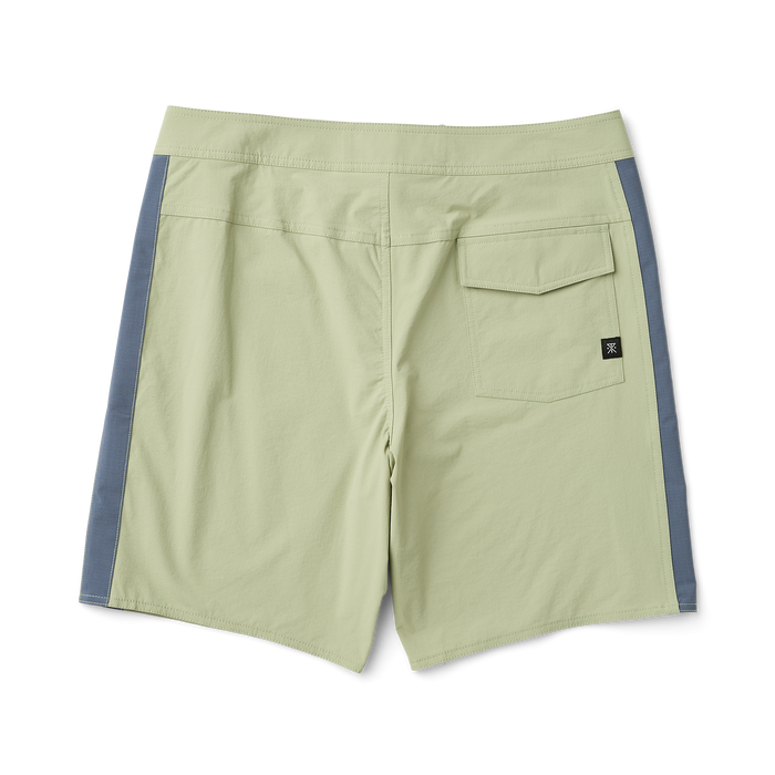 Roark boardshorts styled as Bermuda shorts displayed on rugged outcrop near the ocean, ideal for adventure and travel