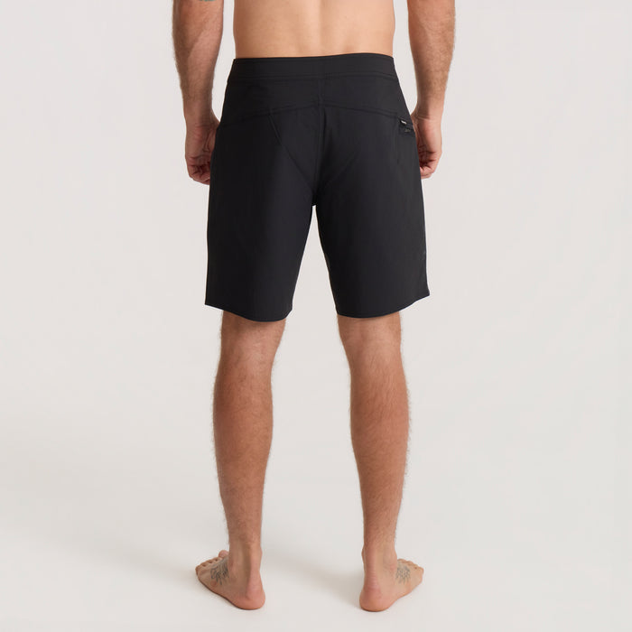 Man wearing black Passage Pro Boardshorts viewed from behind, featuring a fitted cut and back pocket detail