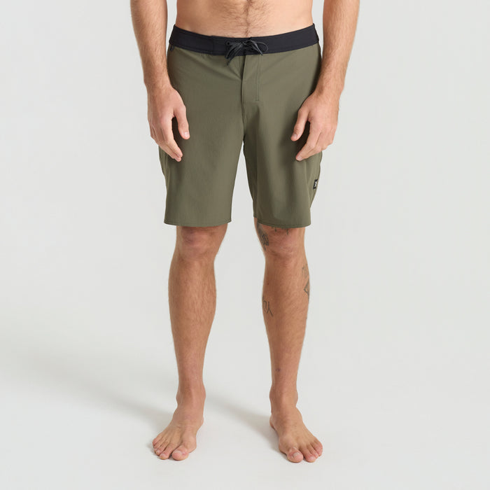 Boardshorts on a scenic, rugged coast, ideal for surfing and beach adventures, capturing Roark's spirit of outdoor exploration.