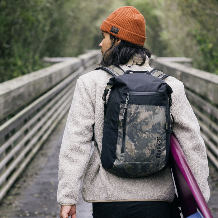 Versatile hiking backpack from Roark, ideal for adventure and travel, showcased in a rustic outdoor setting.