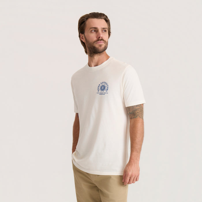 Off-white Points Unknown Premium Tee with blue circular logo on chest, worn by man with beige pants in lifestyle shot