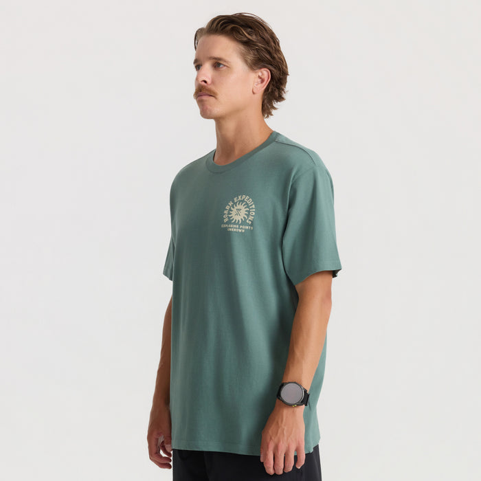 Sage green short sleeve tee with cream circular sun graphic and text on chest, worn by male model in profile view