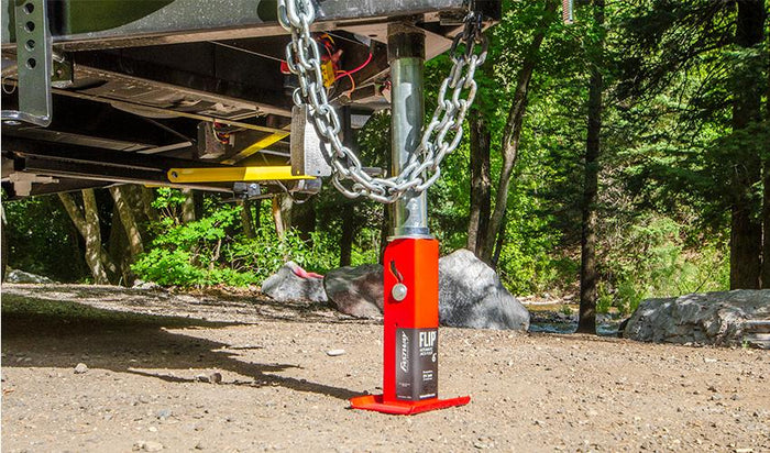 Red FLIP Jack Foot Supporting Trailer in Outdoor Camping Setup | United RV Parts
