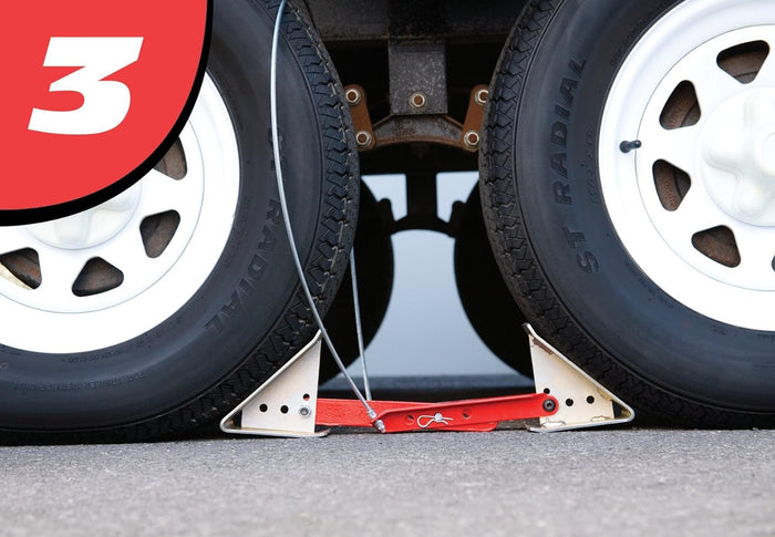 Step 3 – Progress MFG ONESTEP chock 84-00-4840 installed between dual trailer wheels, locked position | United RV Parts