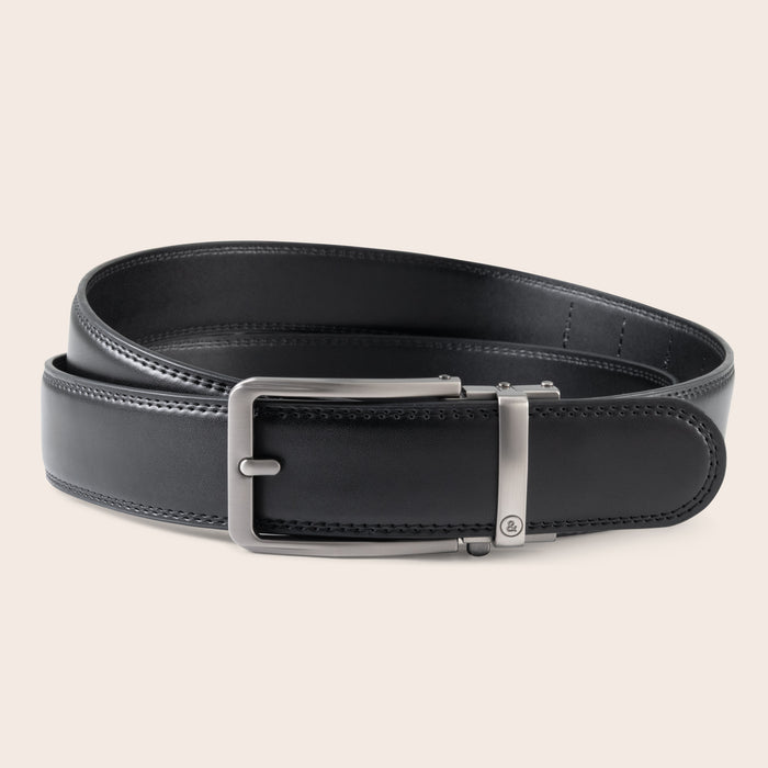 Black leather belt with a silver buckle on a beige background