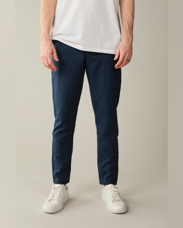 Person wearing midnight blue pants and white sneakers