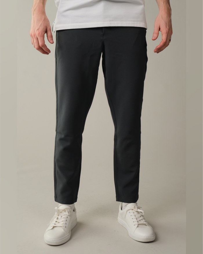Person wearing stone grey pants and white sneakers