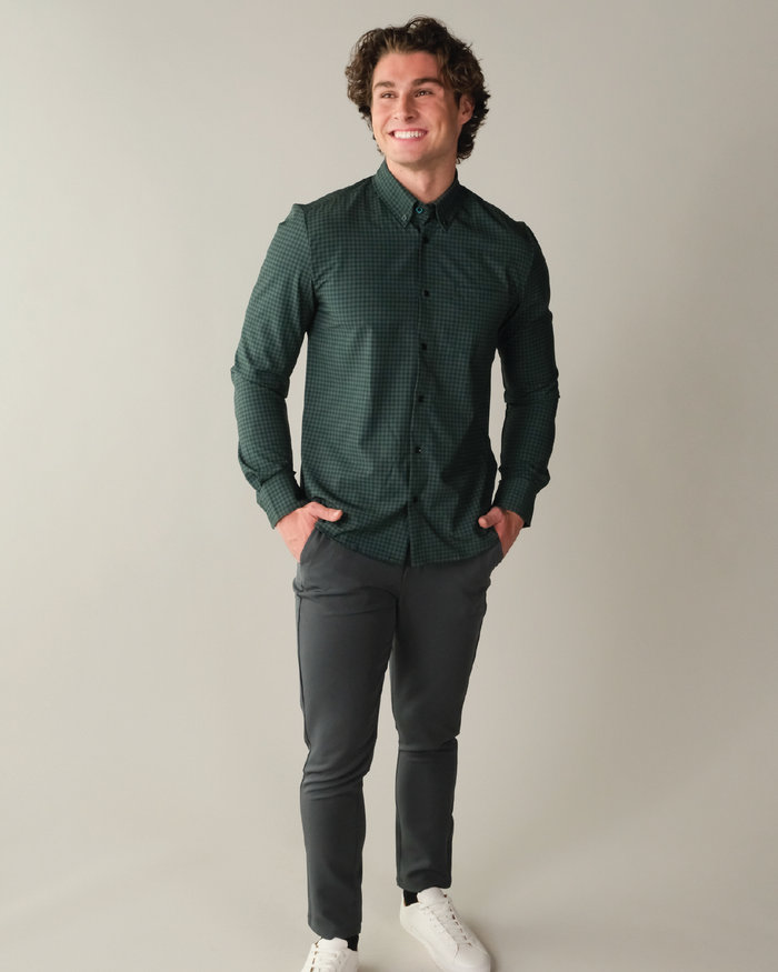 Man wearing forest green and navy gingham shirt. Black buttons. Button down collar.