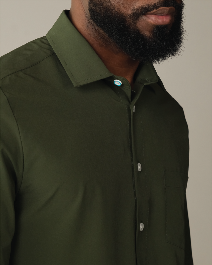 Man wearing a forest green shirt. Top button has blue ring